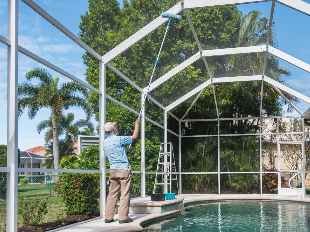 An image of a person cleaning a pool screen
